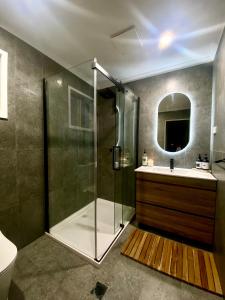 ワイズマンズ・フェリーにあるGlasshouse On The Water PET FRIENDLYのシャワー、洗面台、鏡を備えたバスルーム