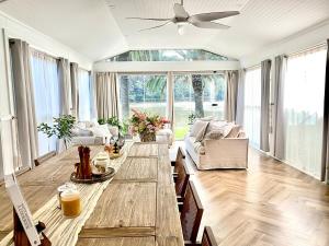 ワイズマンズ・フェリーにあるGlasshouse On The Water PET FRIENDLYのテーブルと天井ファンのあるリビングルーム +18枚の写真