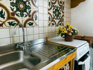 a stainless steel sink in a kitchen with flowers at Novecento Room and Breakfast Puglia in Massafra +160 photos