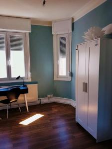 Una habitación con un piano en una habitación con paredes azules. en private Zimmer im Serviced Apartment - mit wöchentlicher Reinigung, en Stuttgart