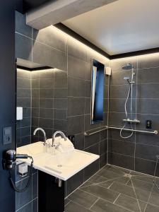 a bathroom with a sink and a shower at BI Hotel by WMM Hotels in Heideloh