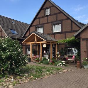 オスターホルツ・シャルムベックにあるB&B Worpsweder Blickの茶色のレンガ造りの家で、正面にパティオがあります。