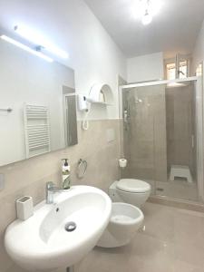 une salle de bain avec un lavabo, des toilettes et une douche dans l'établissement AuGuStea-The Nest of Sannicandro, à Sannicandro di Bari 35 autres photos