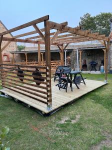 a wooden deck with a table and chairs on it at La petite Irlande in Auderville