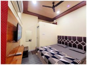 Un dormitorio con una cama y un televisor de pantalla plana. en Hotel Pallav Guest House Near Mahakaleswar Jyotirlinga Temple #Fully Air Conditioning & Spacious Room #Free Wi-fi #Free Parking #Room Service #Best Hotel In Ujjain, en Ujjain 19 fotos más