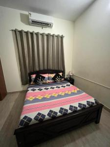 a bedroom with a bed with a striped comforter at Luxe Loop in Mahabalipuram
