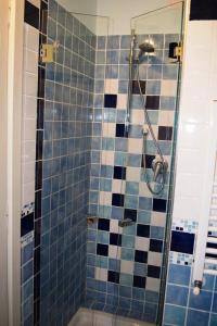 a bathroom with a shower with blue and white tiles at Il Guiscardo B&B in Salerno