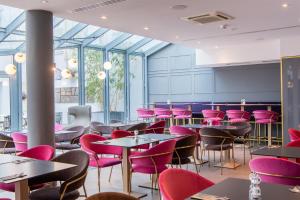 a dining room with tables and pink chairs at Premier Inn Saarbrücken City Centre in Saarbrücken