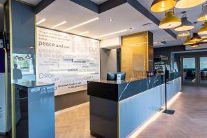 a restaurant lobby with a large screen in the background at Premier Inn Saarbrücken City Centre in Saarbrücken