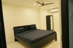 a bedroom with a bed with a ceiling fan at Serene Stays in Chennai +23 photos