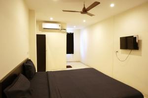 a bedroom with a bed and a ceiling fan at Serene Stays in Chennai