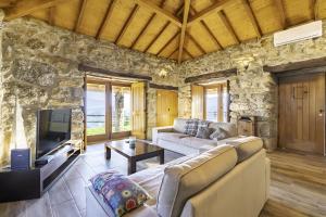 a living room with a couch and a tv at Casa De Basto in Celorico de Basto