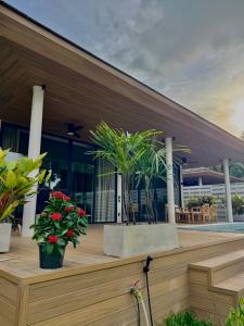 a building with two potted plants on a deck at Siam Residence - Modern Villa with a Private Pool in Koh Phangan