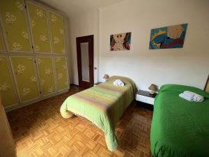 two beds in a room with green walls at Paolo&SilviaHost in Seriate