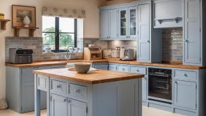 Una cocina con gabinetes blancos y una encimera de madera. en The Long Barn, en Oxford