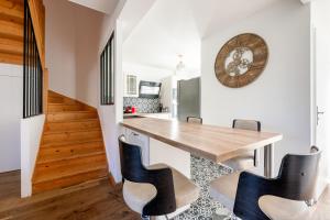 eine Küche mit einem Holztisch und schwarzen Stühlen in der Unterkunft L'Elbe in Serris