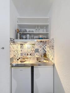 a small kitchen with a sink and a shelf at Ty Breizh - Studio cosy au cœur de Dol-de-Bretagne in Dol-de-Bretagne +4 photos