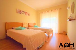 a bedroom with two beds and a window at Luz do Sol in Guia +13 photos