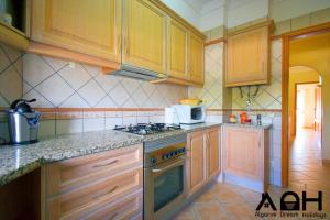 a kitchen with wooden cabinets and a stove top oven at Luz do Sol in Guia