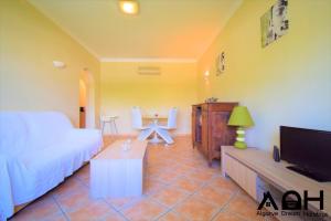 a living room with a bed and a tv at Luz do Sol in Guia