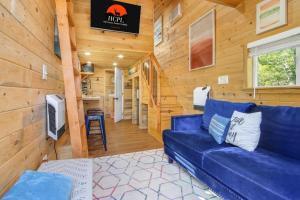 a living room with a blue couch in a cabin at Arbor House of Dripping Springs - Serenity Hollow in Dripping Springs