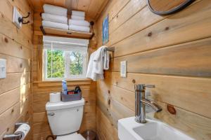 a bathroom with wooden walls and a toilet and a sink at Arbor House of Dripping Springs - Serenity Hollow in Dripping Springs +13 photos
