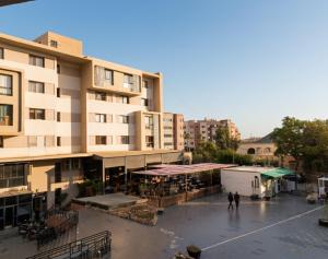 Un edificio de apartamentos con gente caminando en un estacionamiento. en freehome oujda, en Oujda
