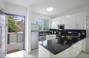 パラリムニにあるVilla Samanthaの白いキャビネットと黒いカウンタートップを備えたキッチン