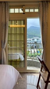 a bedroom with a window with a view of a mountain at Elephant Garden Homestay in Jiaoxi