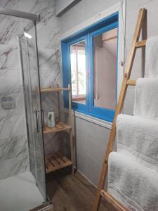 a bathroom with a glass shower door next to a window at CASA DO AVÒ in Castrelo de Miño