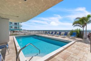 a swimming pool with a view of the ocean at Trillium 2A - Premier in St. Pete Beach