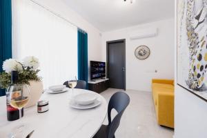 a white living room with a white table and chairs at Ph Jacuzzi &stunningterrace Near Tarxien Temples in Tarxien