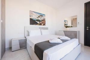 a white bedroom with a large bed in a room at Ph Jacuzzi &stunningterrace Near Tarxien Temples in Tarxien