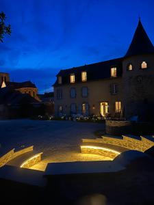 a building with lights in the middle of a courtyard at Chambre avec salle de bain tourelle in Domagné