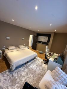 a bedroom with a large bed and a couch at Charmant manoir rénové avec chambres indépendantes et salles de bain privatives, in Domagné