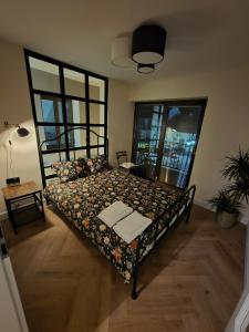 Un dormitorio con una cama con una ventana grande. en Czworobok 39, en Wlodawa