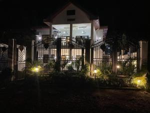 a fence in front of a house at night at 5 Start luxury rooms with presidential Comfort well equipped in Limbe