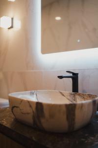 lavabo de piedra en el baño con espejo en Dikubu Belong, en Seminyak