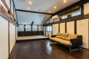 a living room with a couch and a stage at 源泉掛け流し温泉Villa The ITAYA in Yuzawa
