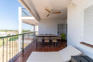 un balcone con tavolo, sedie e ventilatore a soffitto di Doñana Loft 17 a Sanlúcar de Barrameda