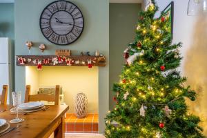 a christmas tree in a kitchen with a table and a clock at Shorethwaite in Amble
