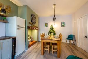 a kitchen and dining room with a table and a christmas tree at Shorethwaite in Amble