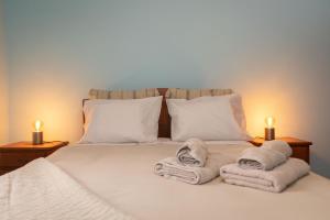 a bed with towels on it with two lit candles at Casa Vale Sereno in Boaventura in Cabo da Ribeira