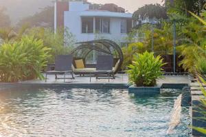 Una piscina con sillas y una casa al fondo. en Casa Magnolia by Da Alohas, en Nerul