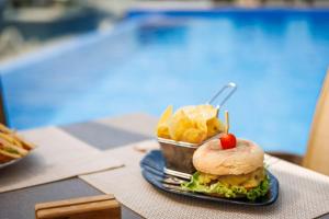 a sandwich and chips on a plate on a table at Jupiter Lisboa Hotel - Rooftop & Spa in Lisbon