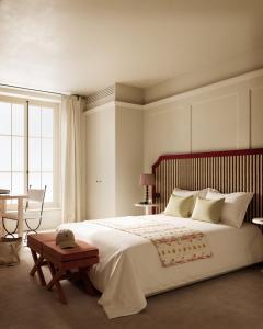 a bedroom with a large bed with a table and a desk at Hotel Splendor Elysées in Paris
