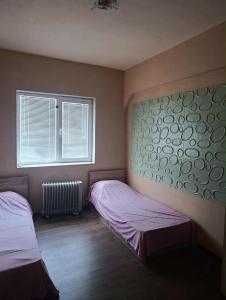 Un dormitorio con dos camas individuales y una ventana. en стаи за настаняване, en Razgrad