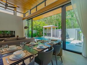 ein Esszimmer mit Tisch und Stühlen und einer Couch in der Unterkunft NEW Cozy 3BR Luxury Pool Villa - Villa Nova in Ban Pak Lak