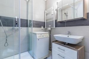 ein weißes Badezimmer mit Waschbecken und Dusche in der Unterkunft CBlue "Kaptain Carl", Terrasse, Grill, Strandnah in Graal-Müritz + 16 Fotos