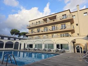 a hotel with a swimming pool and a building at Hotel Canal Olímpic in Castelldefels +40 photos